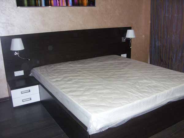 Широкая двуспальная кровать с двумя тумбочками